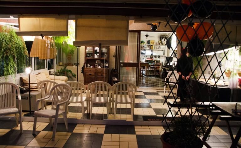 ambiente vintage com iluminação quente, bexigas, plantas, cadeiras, mesa de buffet e garçom