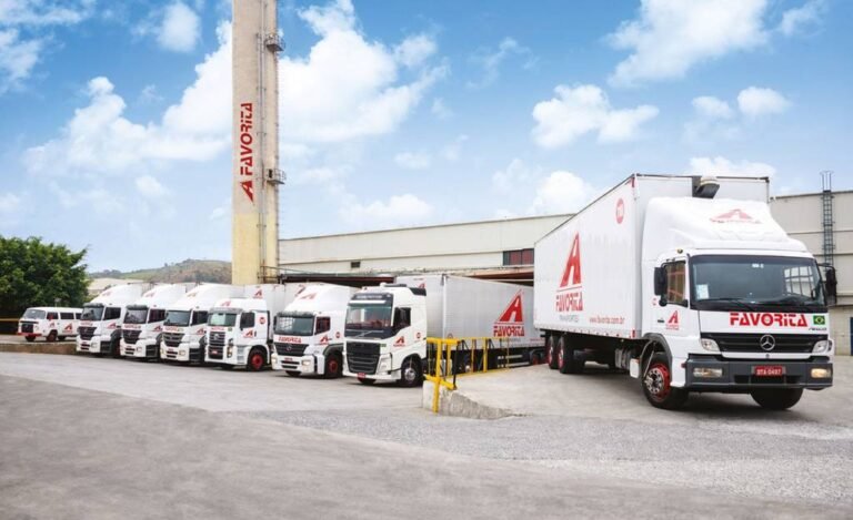 7 caminhões da empresa estacionados paralelamente em pátio da empresa